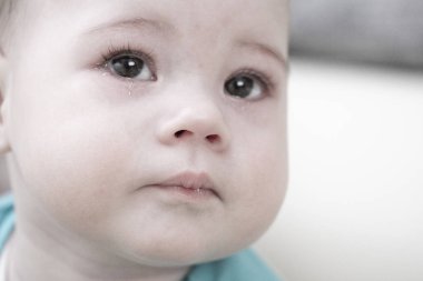 Ağlayan bebek 67 ay, portre yakın çekim. Gözlerinde yaşlar ile bir çocuğun üzgün yüzü, bebek gözyaşları kız çocuk erkek bebek, portre yumuşak odak