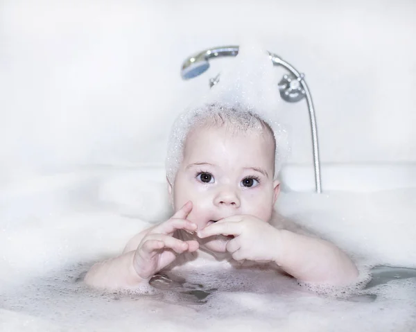 Bebê banha-se em água com espuma — Fotografia de Stock