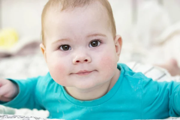 Portret van een 7 maand baby in blauw t-shirt, close-up gezicht portret. Kleine schattige jongen kijkt naar de camera, goed humeur positieve nieuwsgierigheid — Stockfoto