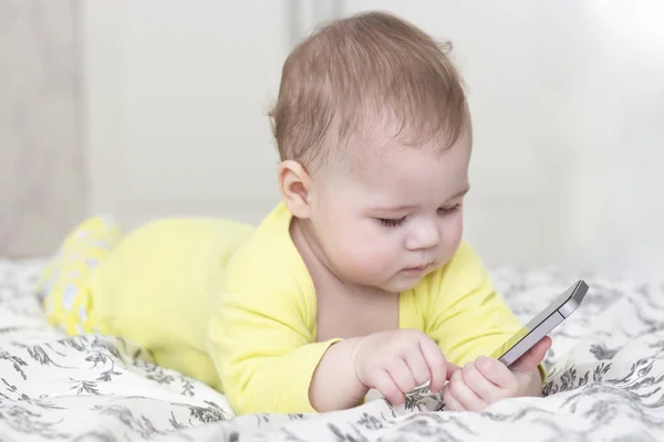 Baby Girl fiú játszik a smartphone. A baba a sárga 6 hónap tartó mobiltelefonnal — Stock Fotó