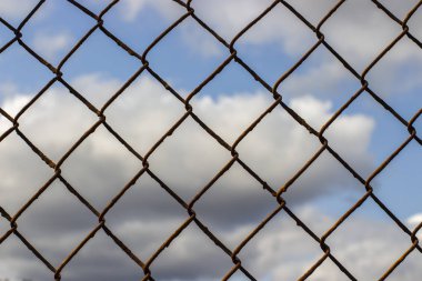 Bulutlar, arka plan duvar kağıdı doku ile mavi bir gökyüzünde eski paslı örgü örgü.