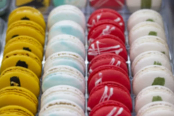 Blurred background showcase confectionery coffee shop. Smooth rows of pastries, cakes, white yellow red white macaroons with crumbs on the counter of a candy store, cafeteria — Stock Photo, Image