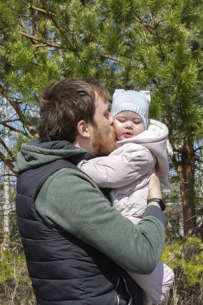 Нежность заботиться о детях любят отца и дочь, молодой человек держит в руках целует малышку — стоковое фото