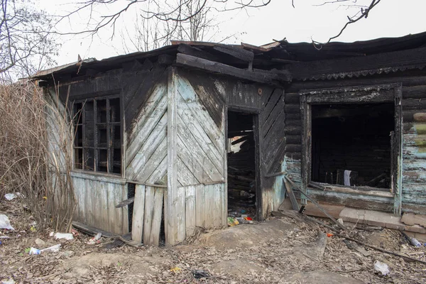 Yangından sonra kır evi. Yanmış ahşap bir evin iskeleti. Kırık kömürleşmiş konut. Kırık kapı camları, siyah duvarlar