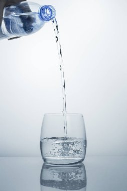 Yüksek bir temiz içme suyu şişeden temiz bir bardağa akar..