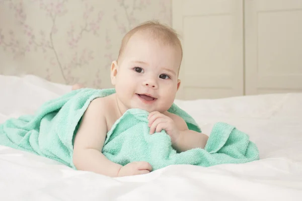 Piękna dziewczynka 6 miesięcy bawiąc się ręcznikiem po kąpieli. Śmiejąc się szczęśliwie. Miękkie skupienie dziecka — Zdjęcie stockowe