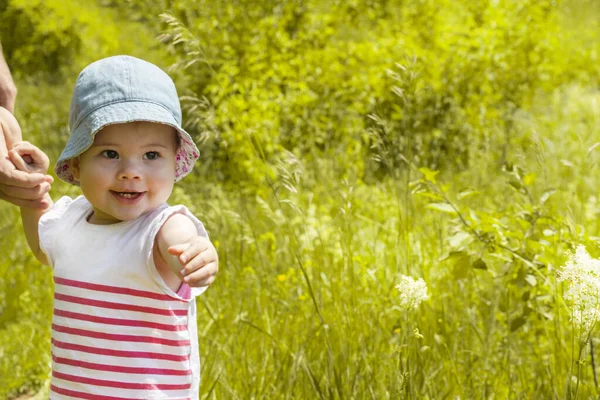 Ребенок 11 месяцев улыбается показывая зубы и дергая руку вперед — стоковое фото
