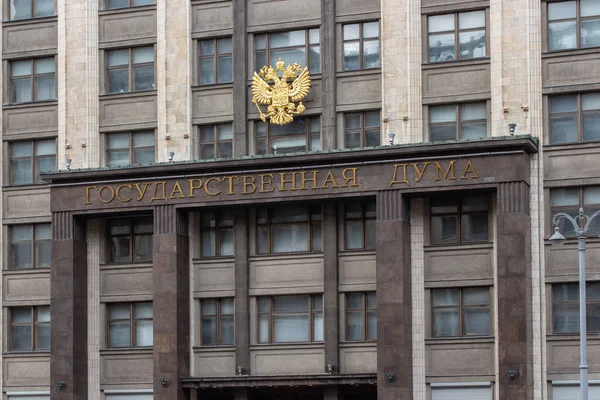 12-10-2019, Moskva, Ryssland. Den centrala fasaden i byggandet av den ryska statsduman. Rysslands gyllene vapensköld en tvåhövdad huvudörn — Stockfoto