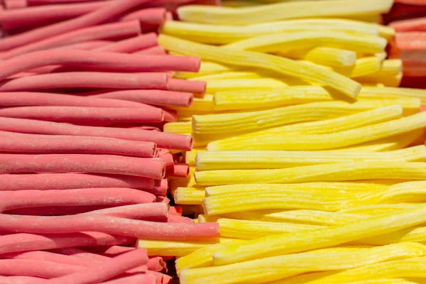 Marshmallow Stick rot rosa gelb, Nahaufnahme Hintergrundtapete. Bonbonmarmelade in einem Supermarkt. ein großer Haufen Fruchtbeeren-Bonbons mit Gelee-Füllung — Stockfoto