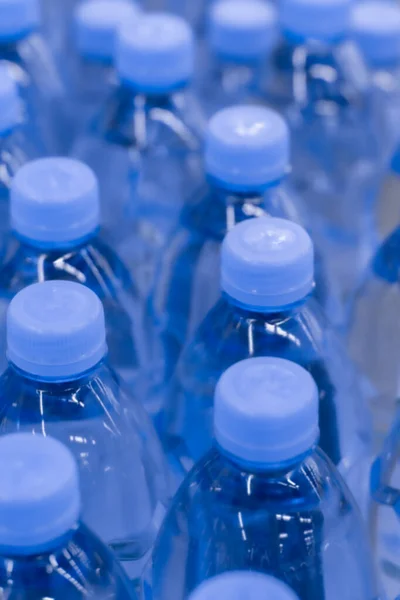 Defocus achtergrond, zuiver drinkwater in plastic flessen. Veel drinkflessen in een supermarkt — Stockfoto