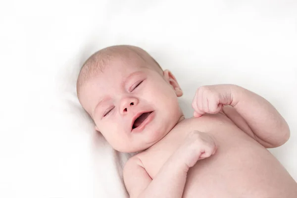Meisje huilend op wit. Pasgeboren baby minder dan een jaar met gebalde vuisten — Stockfoto