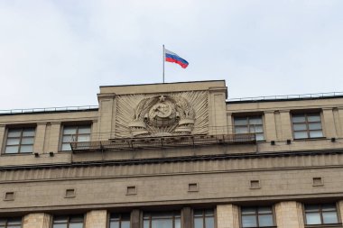 12-10-2019, Moskova, Rusya. Rus ordusunun arması ve Rus bayrağı Duma 'nın çatısında. Orak ve tuval buğday ve taştan kulaklarla çevrili.