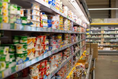 Moskova, Rusya - 23 Ağustos 2020: Büyük bir süpermarkette farklı markalardan süt ürünleri rafı. Boş dükkan ve yoğurtlu vitrin. Süt ürünleri depolamak için büyük buzdolabı