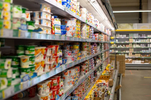 Moskova, Rusya - 23 Ağustos 2020: Büyük bir süpermarkette farklı markalardan süt ürünleri rafı. Boş dükkan ve yoğurtlu vitrin. Süt ürünleri depolamak için büyük buzdolabı