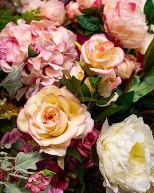 Büyük, açık, pembe şeftali renginde yapay güller, ev dekorasyonu. Tekstil ürünlerinden el yapımı çay gülü. Tasarım için dikey fotoğraf arkaplanı