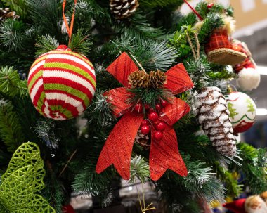Kırmızı bir fiyonkla süslenmiş Noel ağacı, örgü düz top, buz külahı. Şenlikli yeni yıl dekorasyonu arka plan tasarımı yatay.