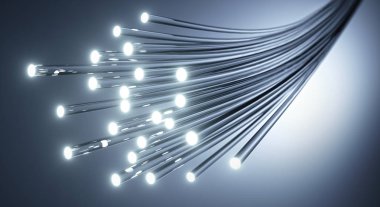 Leuchtendes Glasfaser-Buendel vor Grauverlauf