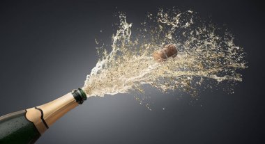 Flasche mitChampagnersplash vor grauem Hintergrund