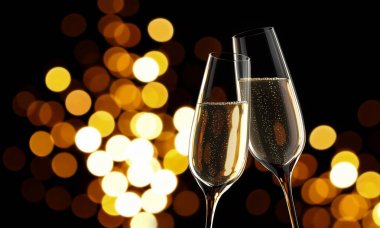 2 Champagnerglaeser beim Anstossen vor unscharfen Lichtern