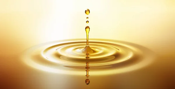 Goldener Tropfen aus Oel mit Spiegelung