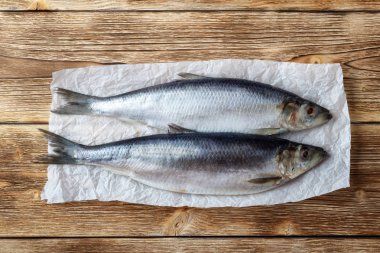 Eski ahşap arka plan üzerinde tuzlu ringa balığı.