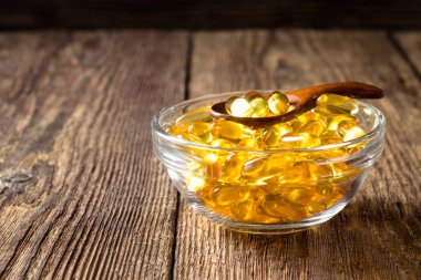 Ahşap arka planda balık yağı kapsüller, D vitamini takviyesi