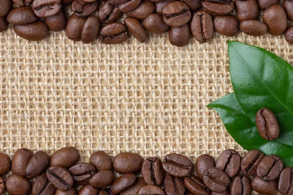 Coffee Border. Beans and leaf over burlap background. Top view with copy space.