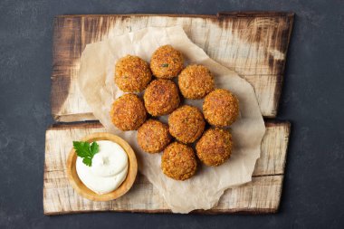Ahşap rustik tahta üzerinde vejetaryen nohut falafel topları. Geleneksel arap yemekleri. Koyu arka plan.