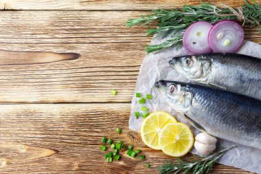 Lezzetli ahşap arka plan üzerinde soğan ve limon ile lezzetli tuzlu ringa balığı. Rustik tarz. Kopya alanı, üst görünüm.