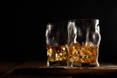 Tahta masada buzlu iki bardak viski. Metin için alanı kopyala.