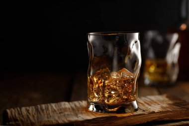 Tahta masada buzlu bir bardak viski. Metin için alanı kopyala.