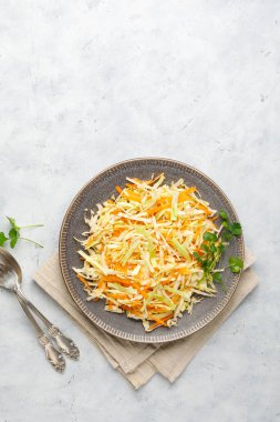 Beyaz arka planda doğranmış lahana ve havuçtan taze lahana salatası. Kopyalama alanı olan üst görünüm.