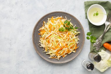 Beyaz arka planda doğranmış lahana ve havuçtan taze lahana salatası. Üst görünüm.