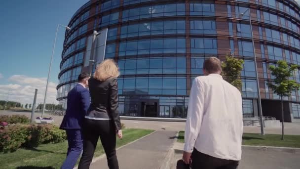 Бізнесмен показує колегам сучасну офісну будівлю зі скла — стокове відео