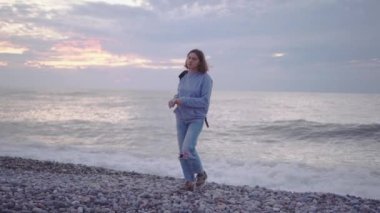 Deniz kenarında sırt çantalı bir kız.