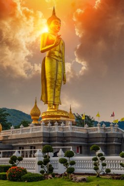 Arka planda güneş ışığı ile Altın gökyüzüne karşı Buda heykeli