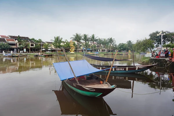 authentic boats moored at lake with tropical greenery on background