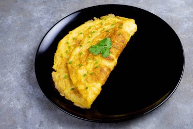 Siyah plaka üzerinde kişniş ve tarya ile ev yapımı omlet