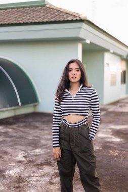 çizgili üst bina çatı üzerinde poz asyalı kadın