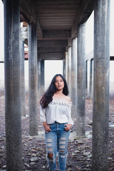 asian woman in top with open shoulders posing at camera