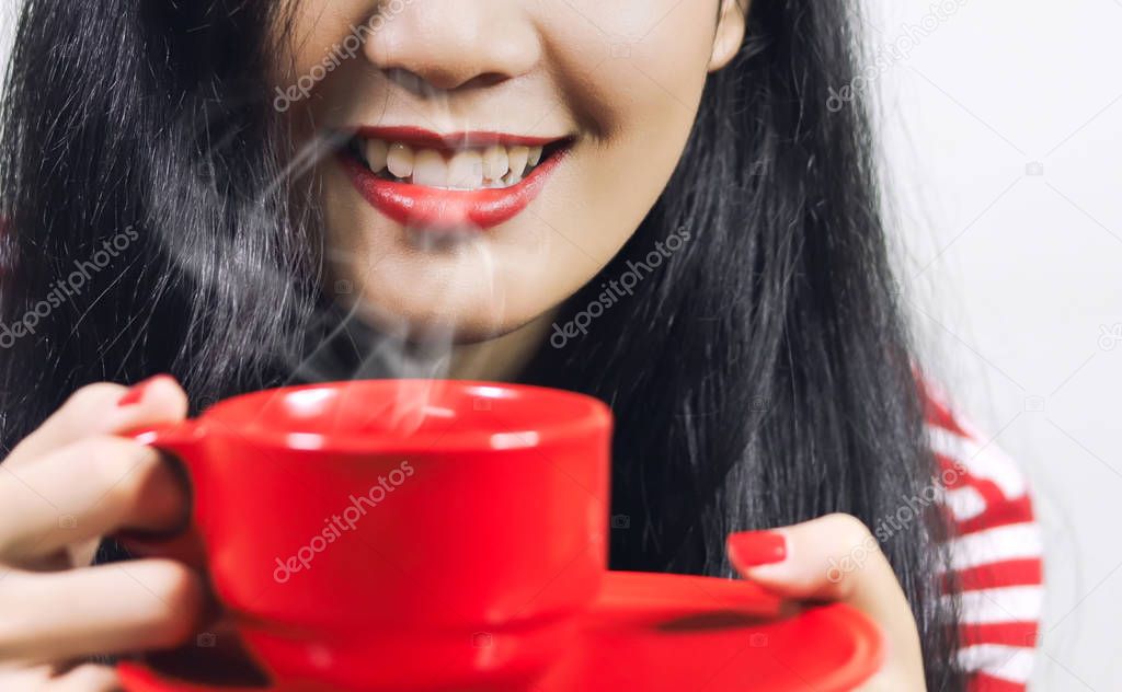 smiling woman in holding red cup of drink, cropped shot