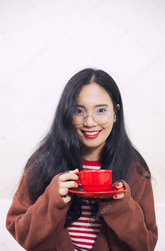 smiling asian woman holding red cup of drink