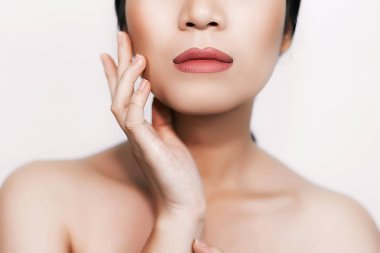 beyaz arka plan üzerinde parlak deri ile genç kadının kırpılmış çekim