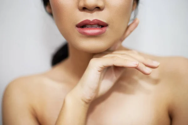 cropped shot of young woman with glossy skin on white background