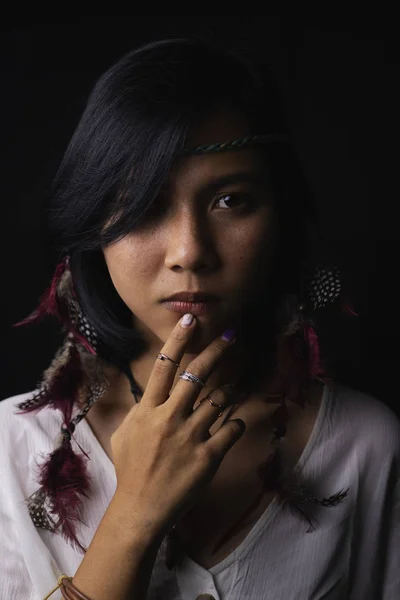 Native American woman\'s face With freckles on the face And jewelry made of leather and feathe