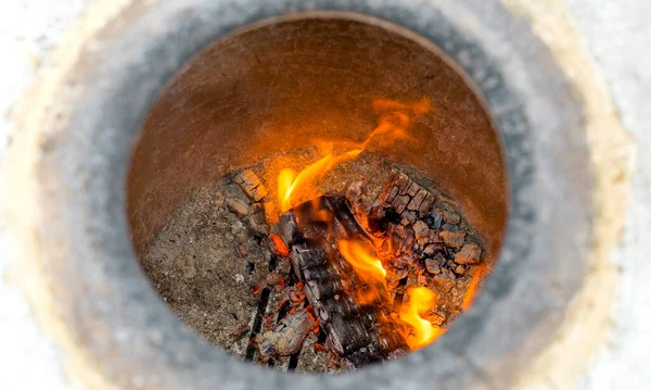 Fire and coals in the clay tandoor. Close up view of working tandoori oven. Shallow depth of field. — Stock Photo, Image