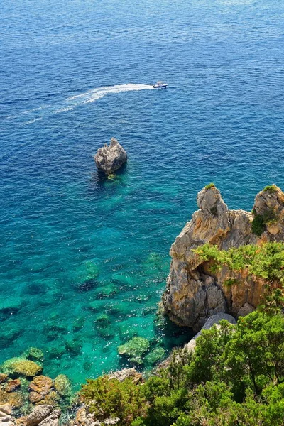 Beautiful beach and boats. Clean sea with a bay. Concept for travel, vacation and tourism. Great place for summer holidays and swimming. Paleokastritsa, Corfu island, Greece.