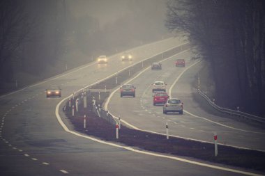 Arabalar sis. Kötü kış hava ve yolda tehlikeli otomobil trafik. Sisli gün hafif araçlar.