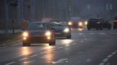 Arabalar sis. Kötü kış hava ve yolda tehlikeli otomobil trafik. Sisli gün hafif araçlar.