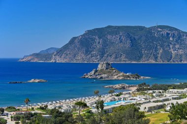 Vrachonisida Kastri - Greece island Kos. Beautiful concept for summer vacation and holiday. Beautiful landscape with sea, island and traditional small greek chapel.Natural colorful background. clipart